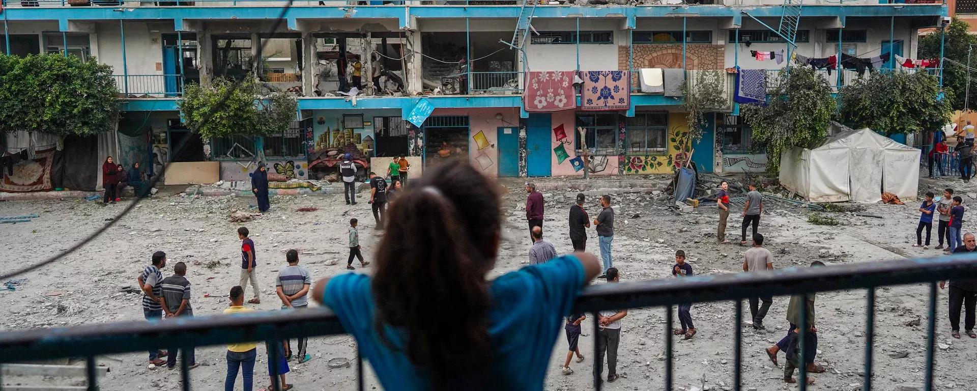 El 6 de junio de 2024, una niña palestina observa una escuela de la ONU que alberga a personas desplazadas y que fue alcanzada durante un bombardeo israelí en Nuseirat, en el centro de la Franja de Gaza. - Sputnik Mundo, 1920, 06.06.2024