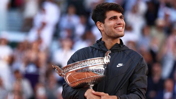 Carlos Alcaraz, deportista español, celebra con el trofeo tras ganar al alemán Alexander Zverev al final de su partido de la final individual masculina en la pista Philippe-Chatrier, París, el 9 de junio de 2024  - Sputnik Mundo