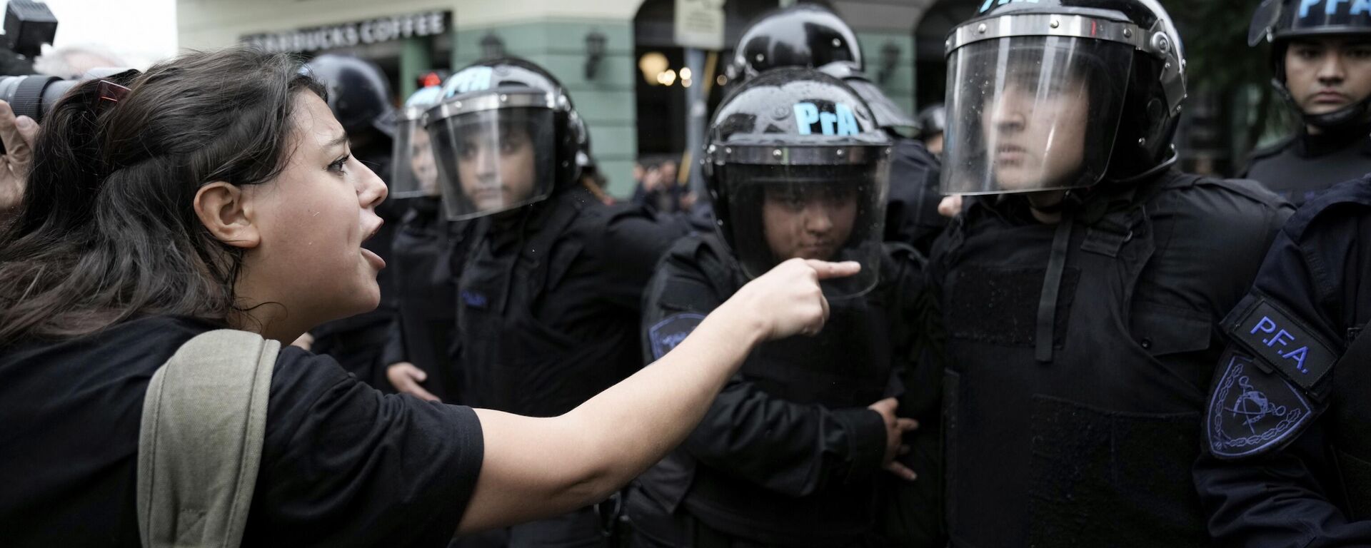 Una manifestante antigubernamental señala a la Policía desplegada frente al Congreso, donde los legisladores debaten un proyecto de reforma promovido por el presidente argentino Javier Milei, el 12 de junio de 2024 - Sputnik Mundo, 1920, 12.06.2024