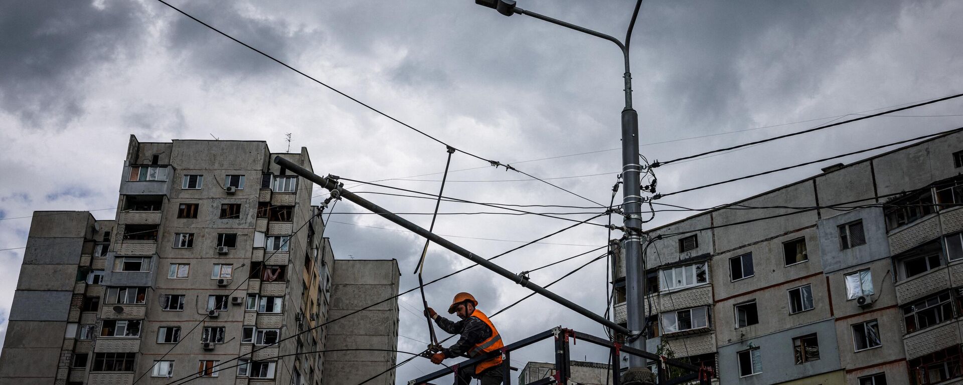 Un trabajador comunal repara las líneas eléctricas cortadas por los bombardeos en Járkov, el 15 de mayo de 2022  - Sputnik Mundo, 1920, 15.06.2024