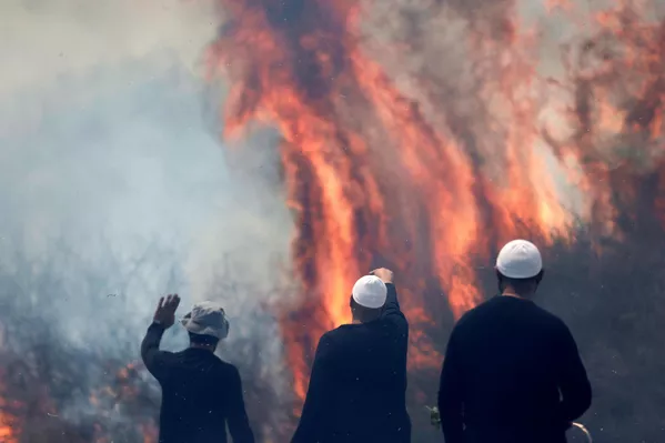 Drusos locales, un grupo étnico-religioso de árabes, observan un incendio tras la caída de cohetes libaneses en el barrio de Banias, Israel. Drusos locales, un grupo étnico-religioso de árabes, observan un incendio tras la caída de cohetes libaneses en el barrio de Banias, Israel. - Sputnik Mundo