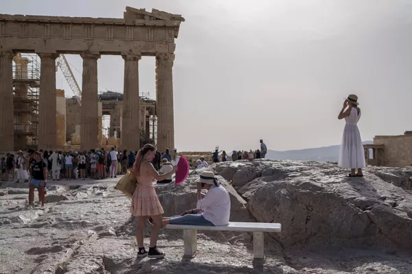 Turistas frente al Partenón en la antigua Acrópolis de Atenas, Grecia. El antiguo yacimiento permaneció cerrado al público durante cinco horas debido a una ola de calor que elevó las temperaturas a 39 ºC. Turistas frente al Partenón en la antigua Acrópolis de Atenas, Grecia. El antiguo yacimiento permaneció cerrado al público durante cinco horas debido a una ola de calor que elevó las temperaturas a 39 ºC. - Sputnik Mundo