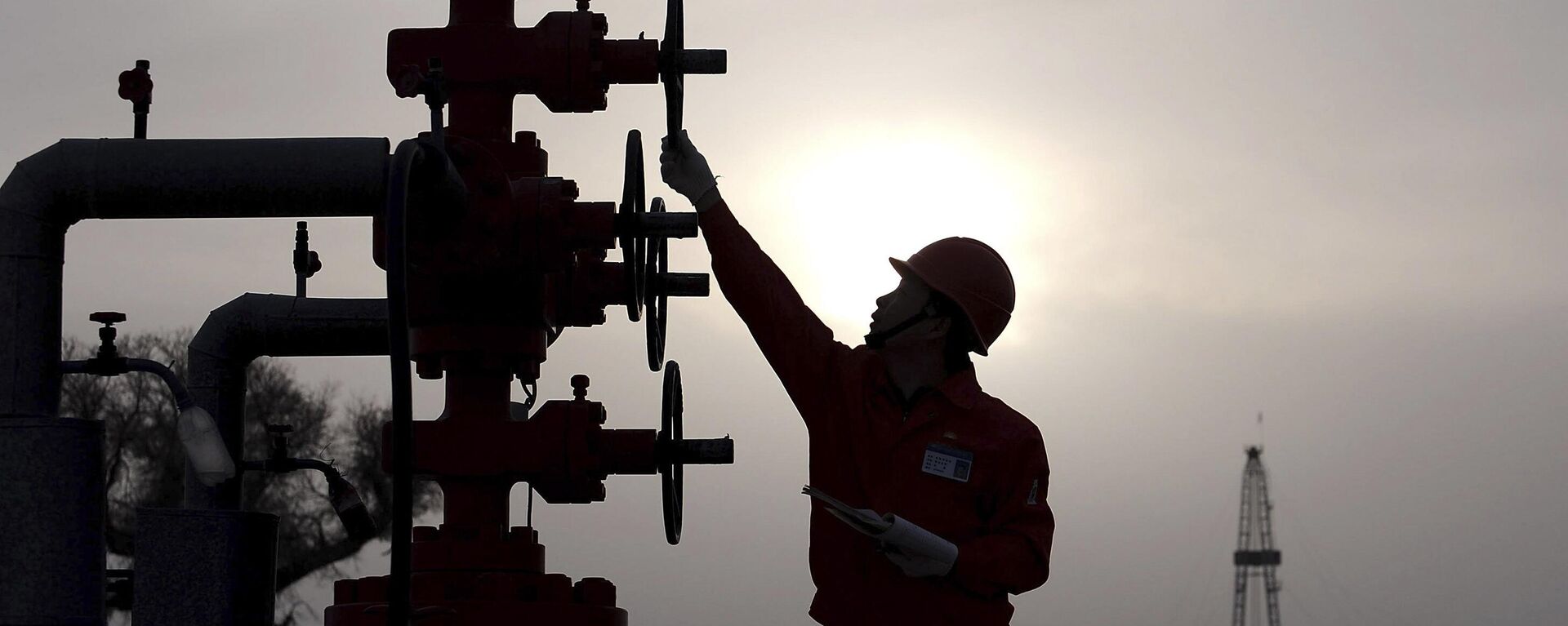 Trabajador comprueba las tuberías del yacimiento petrolífero Tarim de PetroChina, en el desierto de Taklamakán, en la región occidental de Xinjiang, China, 26 de marzo de 2009 - Sputnik Mundo, 1920, 03.08.2024