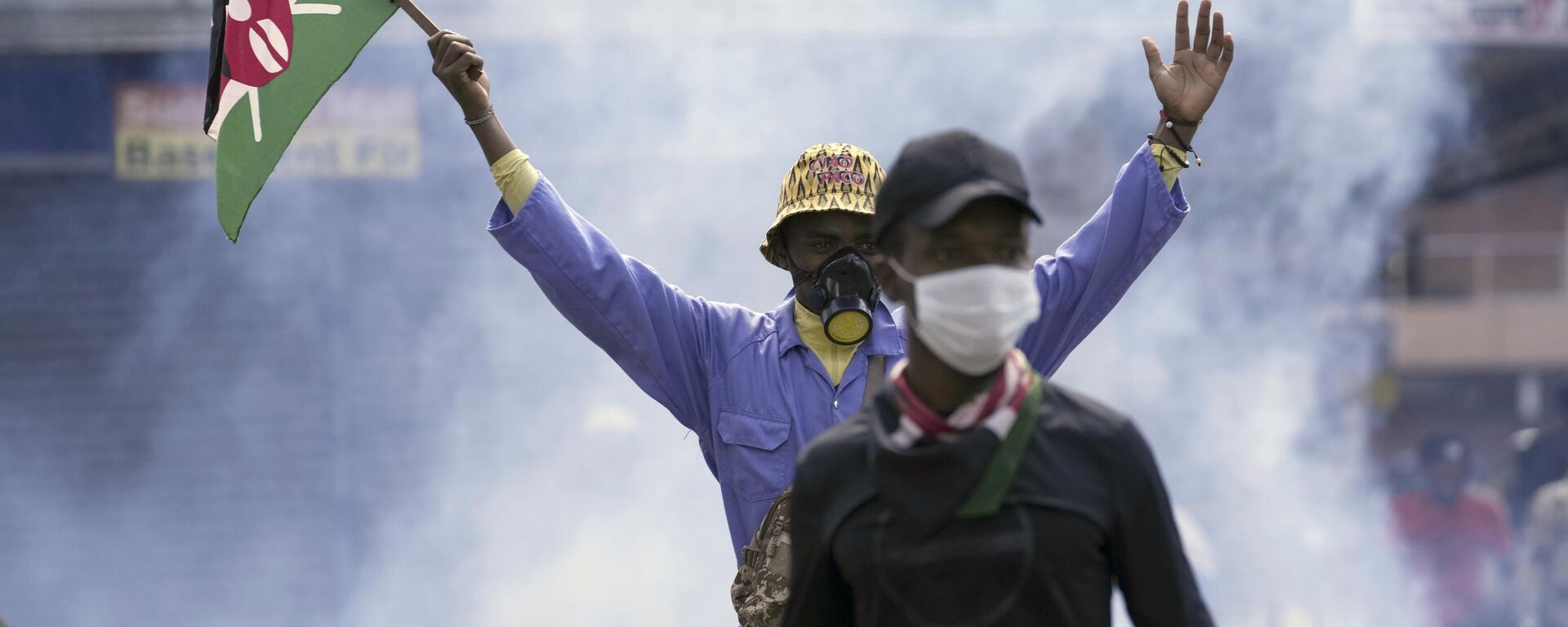 Un manifestante antigubernamental ondea una bandera keniana mientras la policía dispara gases lacrimógenos, el 25 de junio de 2024 - Sputnik Mundo, 1920, 26.06.2024