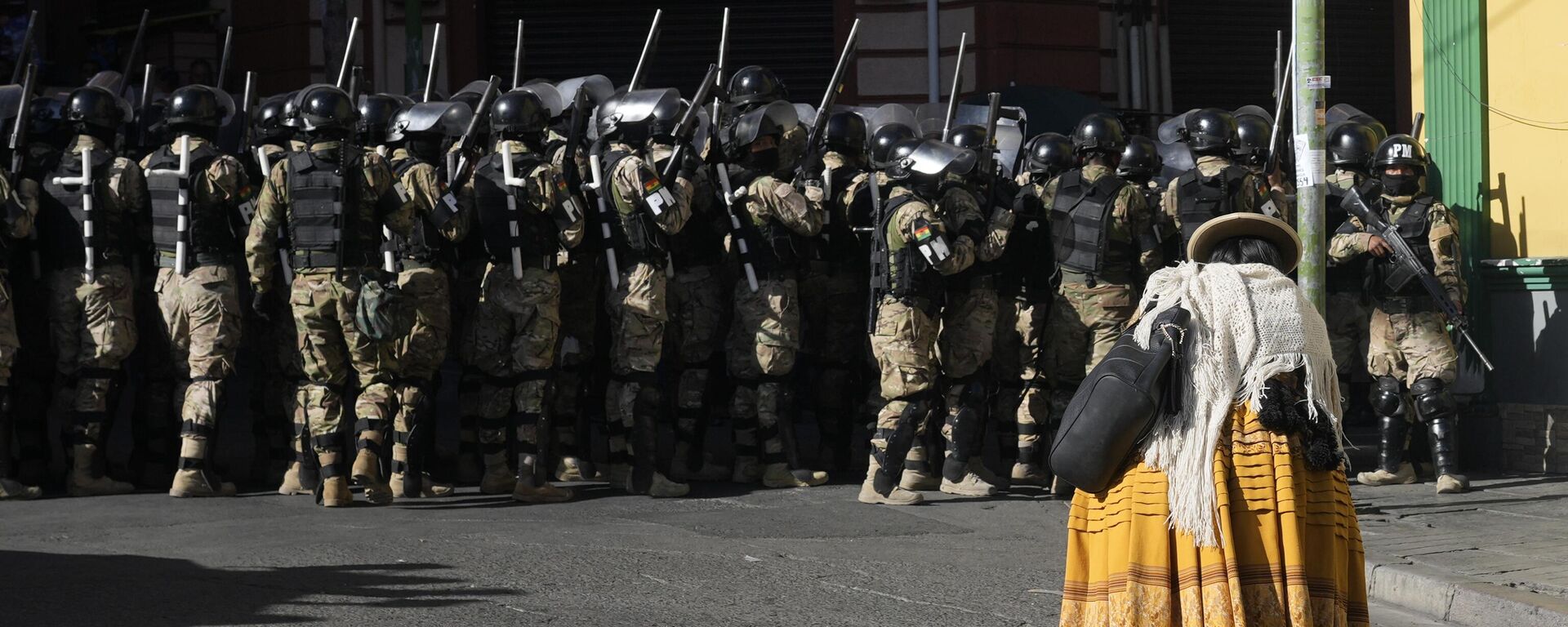 Una mujer pasa junto a policías militares en la Plaza Murillo en La Paz, Bolivia. - Sputnik Mundo, 1920, 27.06.2024