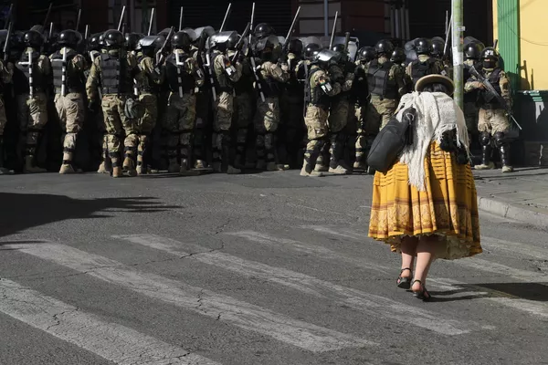Vehículos blindados embistieron las puertas del palacio de Gobierno de Bolivia, ubicado en la Plaza Murillo, cuando Arce señaló que el país enfrentaba un intento de toma de poder.En la foto: una mujer camina al lado de los militares. Vehículos blindados embistieron las puertas del palacio de Gobierno de Bolivia, ubicado en la Plaza Murillo, cuando Arce señaló que el país enfrentaba un intento de toma de poder.En la foto: una mujer camina al lado de los militares. - Sputnik Mundo