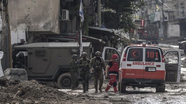 Soldados israelíes se preparan para controlar una ambulancia de la Media Luna Roja palestina a la entrada del campo de refugiados de Tulkarem, en Cisjordania, el 17 de enero de 2024 - Sputnik Mundo