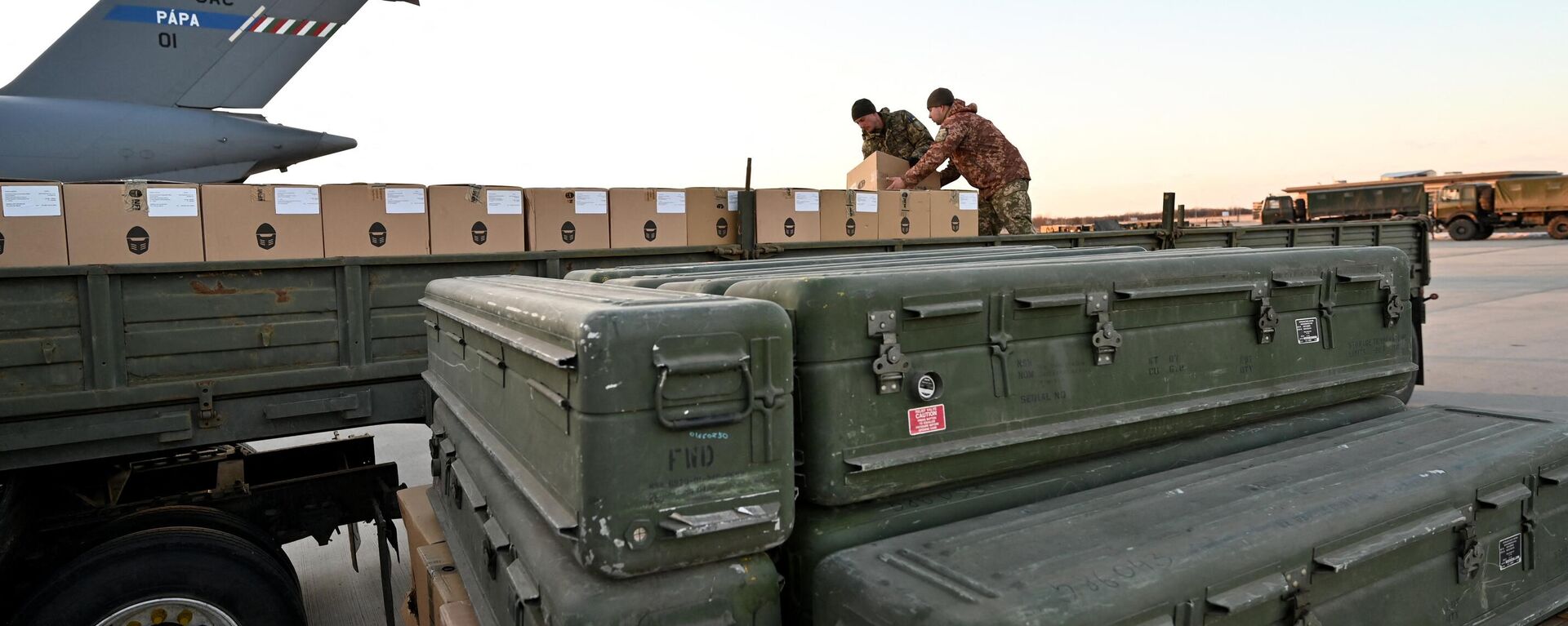 Militares ucranianos cargan un camión de plataforma con cajas mientras se apilan misiles estadounidenses FIM-92 Stinger (frente) y un sistema portátil de defensa antiaérea (Manpads) tras ser enviados al aeropuerto de Boryspil, en Kiev, el 13 de febrero de 2022 - Sputnik Mundo, 1920, 03.07.2024