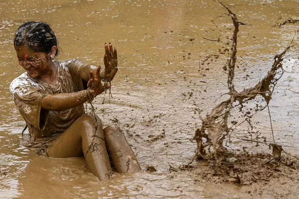 Una chica juega con barro en un arrozal durante el festival anual de arroz en Nepal. Una chica juega con barro en un arrozal durante el festival anual de arroz en Nepal. - Sputnik Mundo