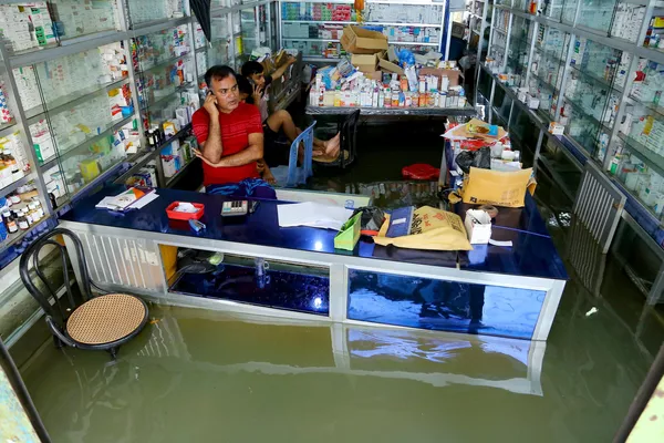 El personal de una tienda de medicamentos espera a los visitantes durante las inundaciones en Bangladés. El personal de una tienda de medicamentos espera a los visitantes durante las inundaciones en Bangladés. - Sputnik Mundo