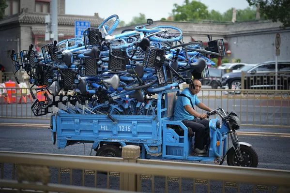 Un trabajador transportando bicicletas en Pekín, China. Un trabajador transportando bicicletas en Pekín, China. - Sputnik Mundo
