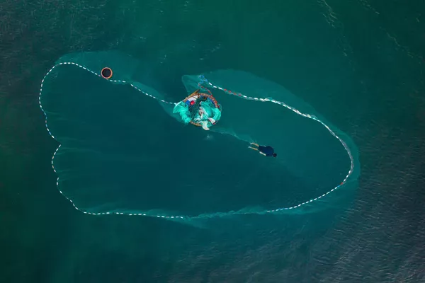 Un hombre tendiendo una red de pesca cerca del pueblo vietnamita de Nhon Hai. Un hombre tendiendo una red de pesca cerca del pueblo vietnamita de Nhon Hai. - Sputnik Mundo