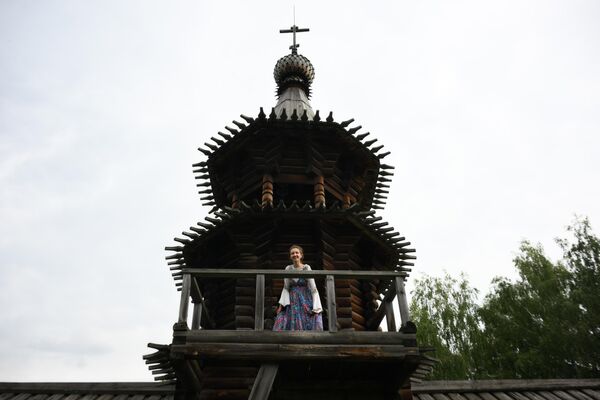 Una participante en el festival cerca de la Iglesia del Salvador que fue construida en el siglo XVIII en la ciudad polar de Zashiversk, en Yakutia.A finales del siglo XIX la ciudad dejó de existir, y en 1971 la iglesia fue desmantelada y transportada a Novosibirsk. - Sputnik Mundo