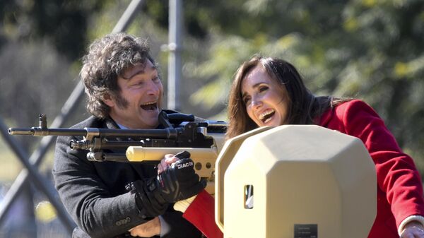 El presidente argentino Javier Milei (izquierda) y su vicepresidenta Victoria Villarruel suben a un tanque blindado durante el desfile militar del Día de la Independencia en Buenos Aires, Argentina. - Sputnik Mundo