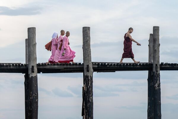 Monjes budistas caminan por el puente U Bein del lago Taungthaman en Mandalay, Birmania. Monjes budistas caminan por el puente U Bein del lago Taungthaman en Mandalay, Birmania. - Sputnik Mundo