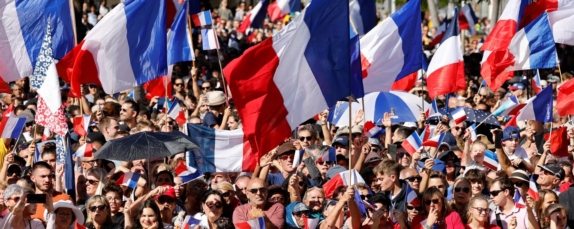 Una multitud ondea banderas francesas mientras el presidente Emmanuel Macron pronuncia su discurso en la Place des Cocotiers en Noumea el 26 de julio de 2023. - Sputnik Mundo, 1920, 20.07.2024