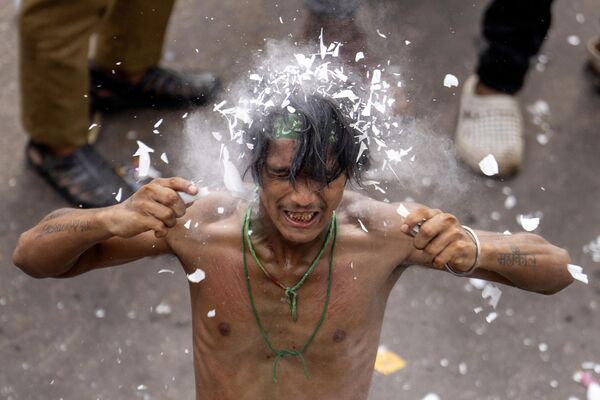 El muharram es el primer mes del calendario musulmán y uno de los cuatro meses sagrados del año en el que se prohíbe la guerra.En la foto: un creyente rompe un tubo de luz sobre su cabeza con motivo de muharram en la India. - Sputnik Mundo