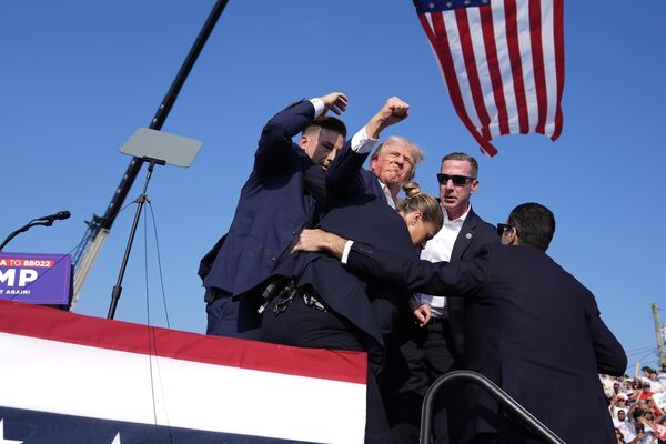 El 13 de julio, el expresidente y candidato puntero en las elecciones presidenciales de EEUU, Donald Trump, sufrió un atentado en su contra durante un evento que encabezó en Pensilvania.En la imagen: Donald Trump hace un gesto mientras abandona el escenario del mitin electoral tras el atentado. - Sputnik Mundo