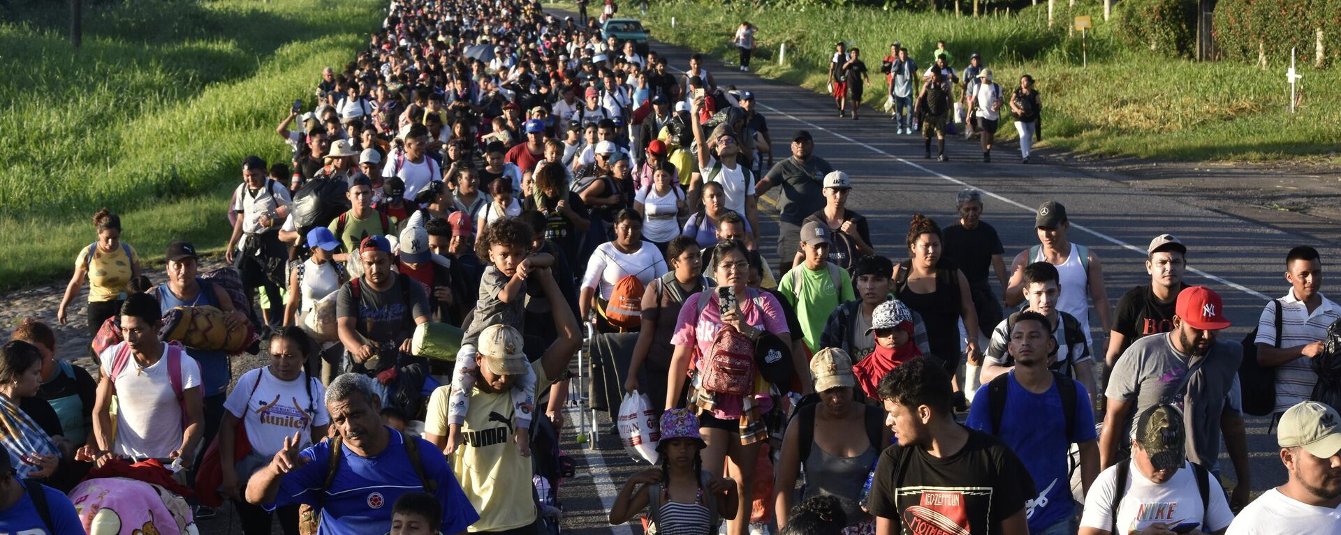 Integrantes de la caravana de migrantes caminan por la carretera que atraviesa Suchiate, en el sureño estadp de Chiapas, México, el domingo 21 de julio de 2024, durante su viaje hacia Estados Unidos - Sputnik Mundo, 1920, 24.07.2024