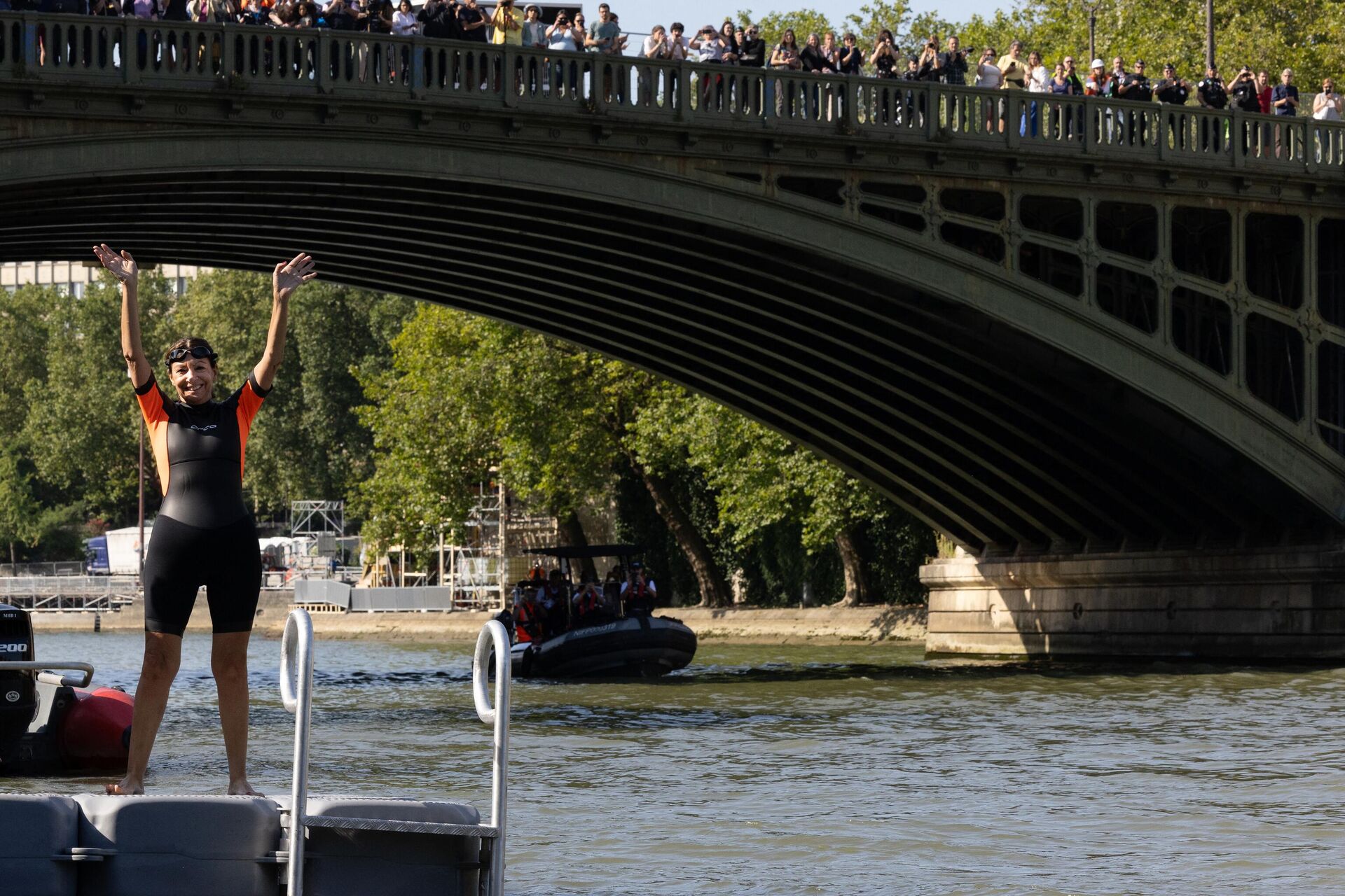 La alcaldesa de París, Anne Hidalgo, saluda antes de nadar en el río Sena, en París, el 17 de julio de 2024, para demostrar que el río está lo suficientemente limpio como para albergar los eventos de natación al aire libre en los Juegos Olímpicos  - Sputnik Mundo, 1920, 26.07.2024