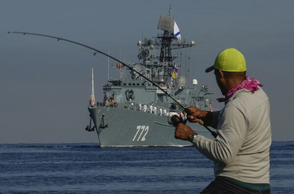 Un pescador enrolla su caña mientras el patrullero Neustrahimy llega en la bahía de La Habana. - Sputnik Mundo