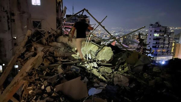 Un hombre inspecciona un edificio destruido en un ataque aéreo israelí contra los suburbios del sur de Beirut, Líbano. - Sputnik Mundo