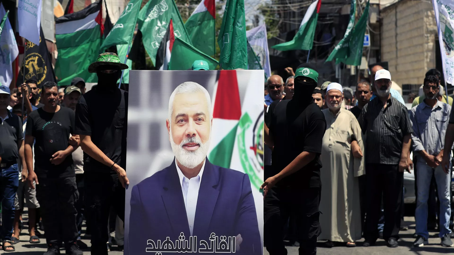 Miembros de Hamás sostienen un cartel del jefe político de Hamás, IIsmail Haniyá, durante una protesta para condenar su asesinato, en el campo de refugiados palestinos de al Bass, en la ciudad portuaria meridional de Tiro, Líbano, el 31 de julio de 2024 - Sputnik Mundo, 1920, 24.12.2024