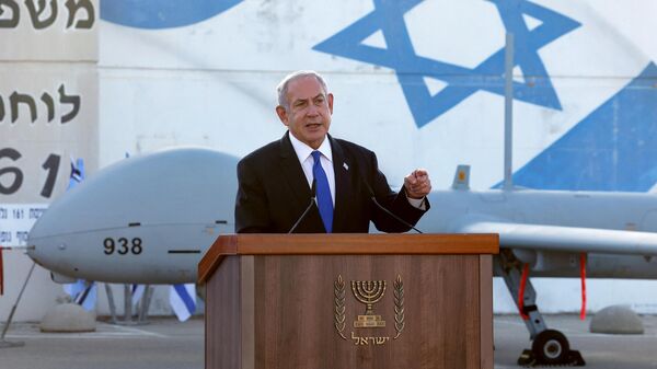 El primer ministro israelí, Benjamín Netanyahu, delante de un dron Hermes 900 mientras pronuncia un discurso durante su visita a un centro israelí de vehículos aéreos no tripulados (UAV), en la base aérea de Palmachim, cerca de la ciudad de Rishon LeZion, el 5 de julio de 2023. - Sputnik Mundo