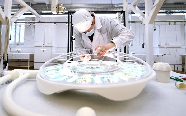 La planta Zavod EMA fue fundada en 1941. Es el único fabricante ruso de luminarias médicas.En la foto: un empleado de la fábrica de la ciudad rusa de Ekaterimburgo limpia el cristal protector de una luminaria médica antes de su instalación. - Sputnik Mundo