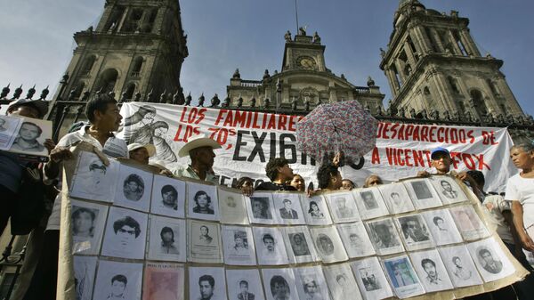Familiares de personas desaparecidas durante la Guerra Sucia en México muestran fotografías en la Ciudad de México, el martes 4 de abril de 2006 (imagen referencial) - Sputnik Mundo