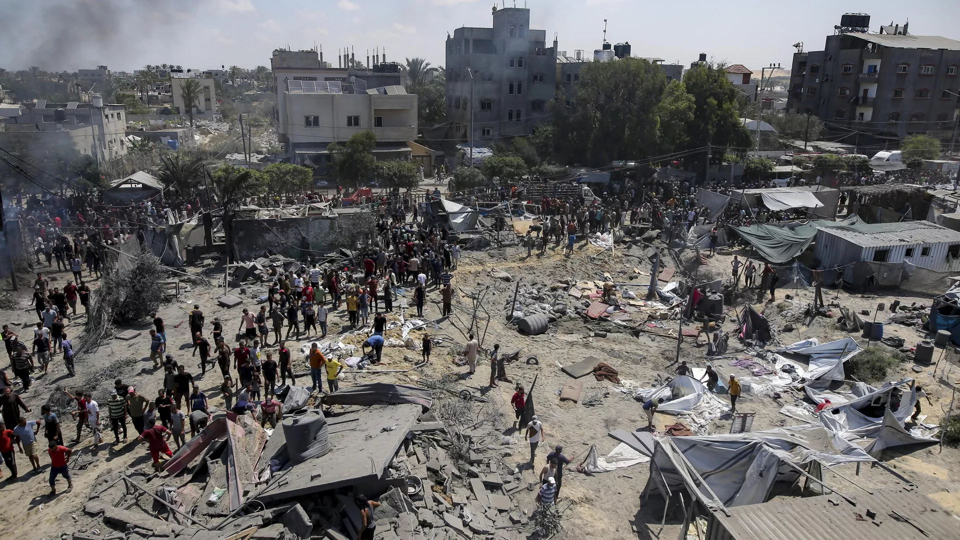 Palestinos inspeccionan los daños en un lugar afectado por un bombardeo israelí en Jan Yunis, al sur de la Franja de Gaza, el sábado 13 de julio de 2024. 