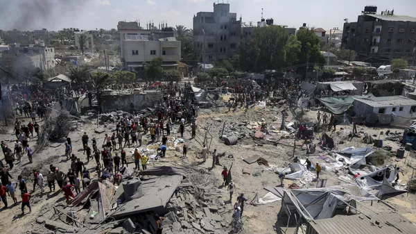 Palestinos inspeccionan los daños en un lugar afectado por un bombardeo israelí en Jan Yunis, al sur de la Franja de Gaza, el sábado 13 de julio de 2024.  - Sputnik Mundo