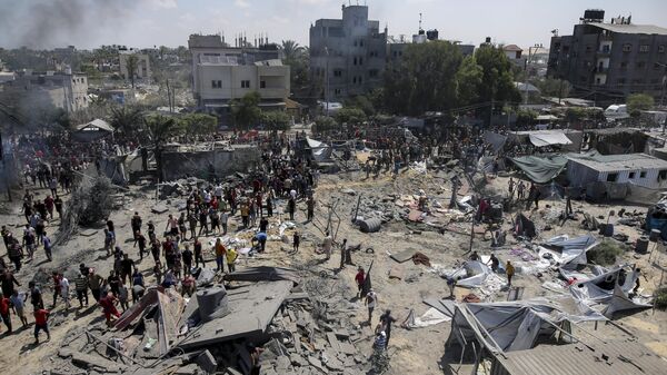 Palestinos inspeccionan los daños en un lugar afectado por un bombardeo israelí en Jan Yunis, al sur de la Franja de Gaza, el sábado 13 de julio de 2024.  - Sputnik Mundo