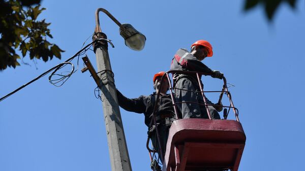 Empleados de servicios públicos durante el restablecimiento de la red eléctrica  - Sputnik Mundo