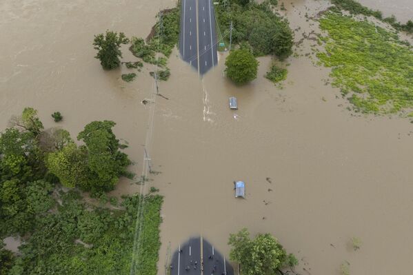 El río La Plata inunda una carretera tras el paso de la tormenta tropical Ernesto por Toa Baja, Puerto Rico. - Sputnik Mundo