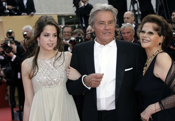 Sus trabajos fueron reconocidos con numerosos galardones en festivales internacionales de cine: Premios César 1985 y Palma de Oro honorífica del Festival de Cannes 2019.En la foto: el actor con su hija Anouchka Delon (izda.) y la actriz Claudia Cardinale (dcha.) llegan a la proyección de la película Wall Street 2: el dinero nunca duerme en Cannes, 14 de mayo de 2010. - Sputnik Mundo