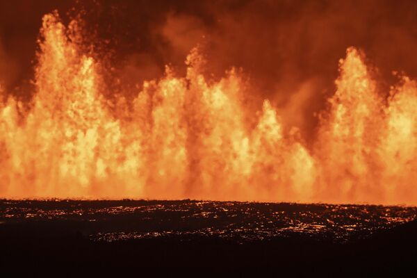 Las fuentes de lava que brotan de la nueva fisura eruptiva abierta en el sistema volcánico de Svartsengi, Islandia.La fisura se encuentra a 3 km al norte de Grindavík. - Sputnik Mundo