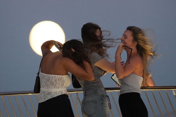 Turistas alemanes observando la salida de la superluna desde el tejado del Museo de Arte, Arquitectura y Tecnología de Lisboa, en Portugal. - Sputnik Mundo