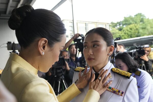 La hermana mayor de la recién elegida primera ministra de Tailandia, Paethongtarn Shinawatra, arregla su corbata antes de la ceremonia de refrendo real en Bangkok. - Sputnik Mundo