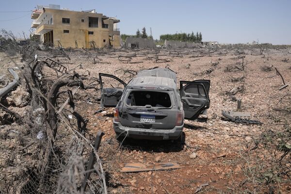 Un automóvil destruido en un campo dañado por un ataque aéreo israelí en la localidad libanesa de Nabi Chit. - Sputnik Mundo