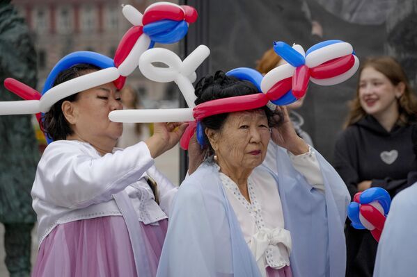 Mujeres con sombreros de globos con los colores de la bandera rusa durante la celebración del Día de la Bandera Nacional de Rusia, en la ciudad de San Petersburgo. - Sputnik Mundo