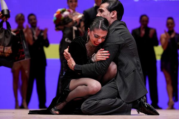 Los argentinos Sebastián Martínez y Ayelén Morando, de Buenos Aires, se abrazan después de ganar la final de la categoría tango escenario. - Sputnik Mundo