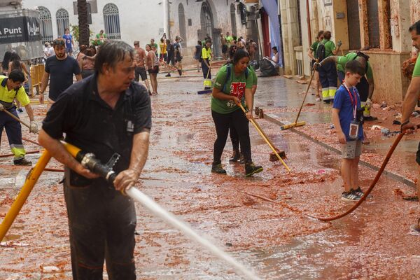 Antes y después de la batalla, hay presentaciones teatrales musicales, concursos y ferias en la ciudad.En la foto: la gente limpia la calle después de la fiesta. - Sputnik Mundo