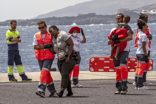 Migrantes desembarcan en el puerto de La Estaca en la ciudad española de Valverde, tras 13 días de travesía en barco desde la costa de Senegal. - Sputnik Mundo