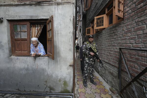 Jammu y Cachemira es un territorio de la unión de la India, ubicado en el norte del país y en disputa con el vecino Pakistán.En la imagen: una residente de Cachemira y un paramilitar durante la campaña previa a las elecciones legislativas del estado de Jammu y Cachemira. - Sputnik Mundo