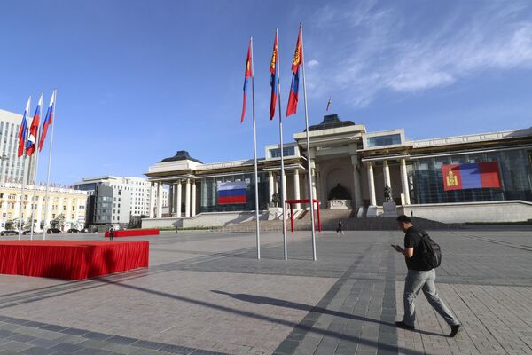 Vladímir Putin invitó a su homólogo mongol a la próxima cumbre de los BRICS, que tendrá lugar en la ciudad rusa de Kazán en octubre.En la foto: un hombre pasa por delante de la plaza Sukhbaatar, decorada con las banderas nacionales de Mongolia y Rusia. - Sputnik Mundo