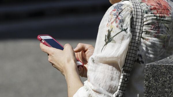 Una mujer utiliza su teléfono móvil (imagen referencial)  - Sputnik Mundo