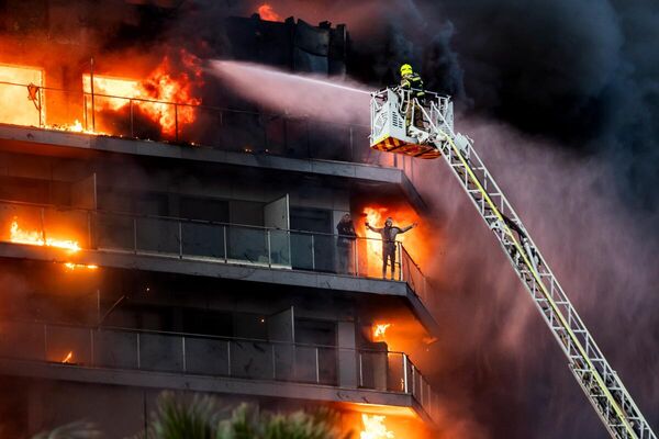 Segundo puesto en la sección Noticias principales era para el español Germán Caballero con su obra Desesperación al borde de la vida y la muerte.En el barrio de Campanar de Valencia, una mujer gesticula para llamar la atención de un bombero durante un devastador incendio.Rescatadas al cabo de dos horas, 10 personas murieron en el incendio. - Sputnik Mundo