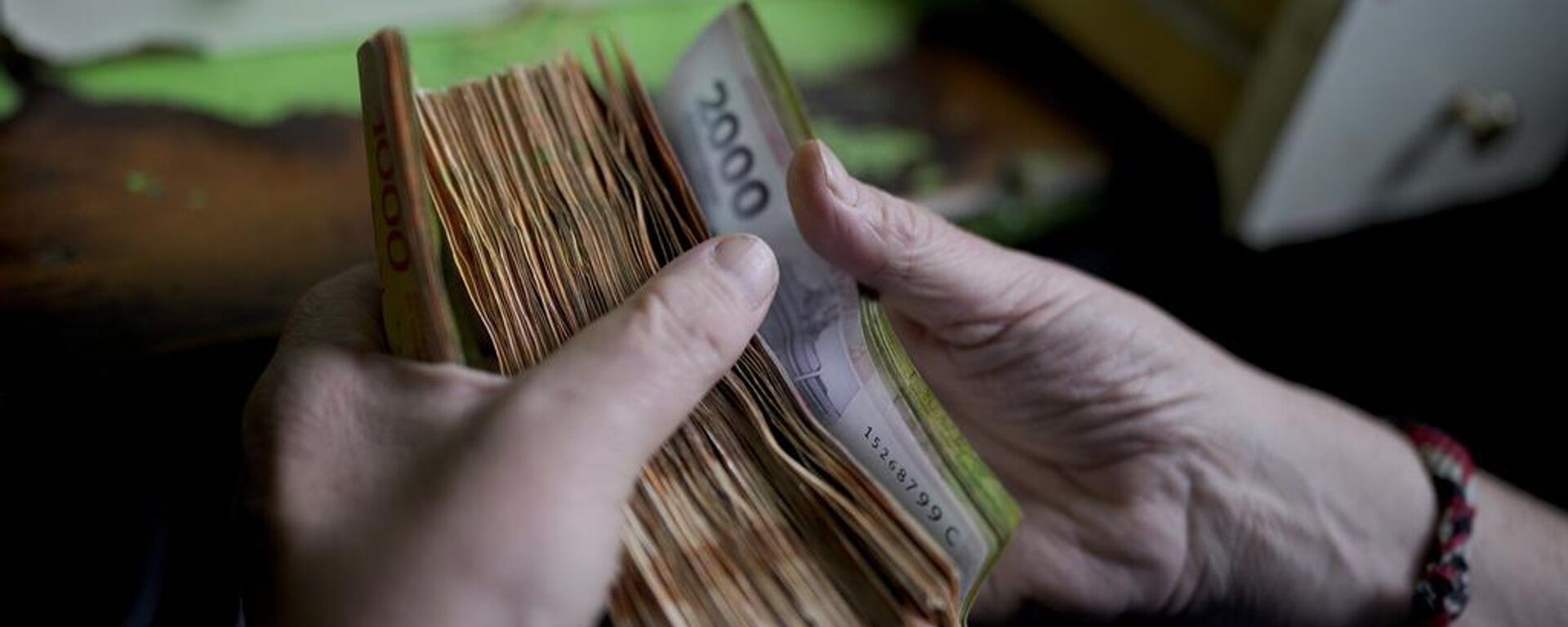 Un trabajador cuenta dinero en una tienda de comestibles en Buenos Aires, Argentina.  - Sputnik Mundo, 1920, 05.09.2024