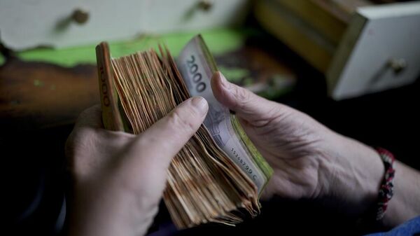 Un trabajador cuenta dinero en una tienda de comestibles en Buenos Aires, Argentina.  - Sputnik Mundo